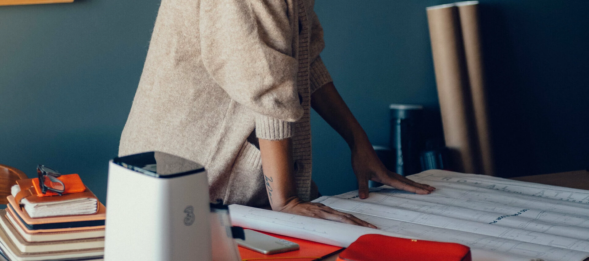 Person som står lutad med händerna på ett kontorsbord.