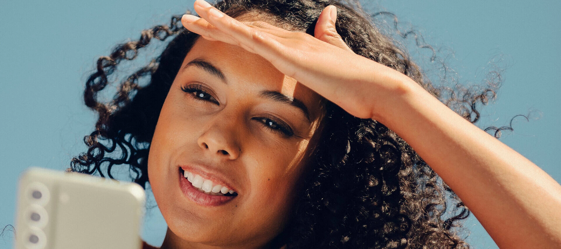 Kvinna som försöker läsa något på sin mobil.