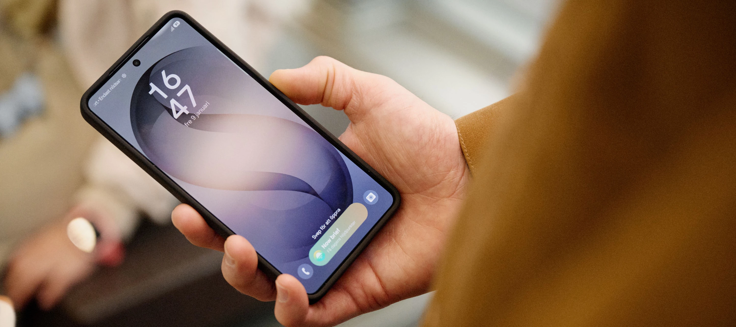 En hand som håller i en mobiltelefon