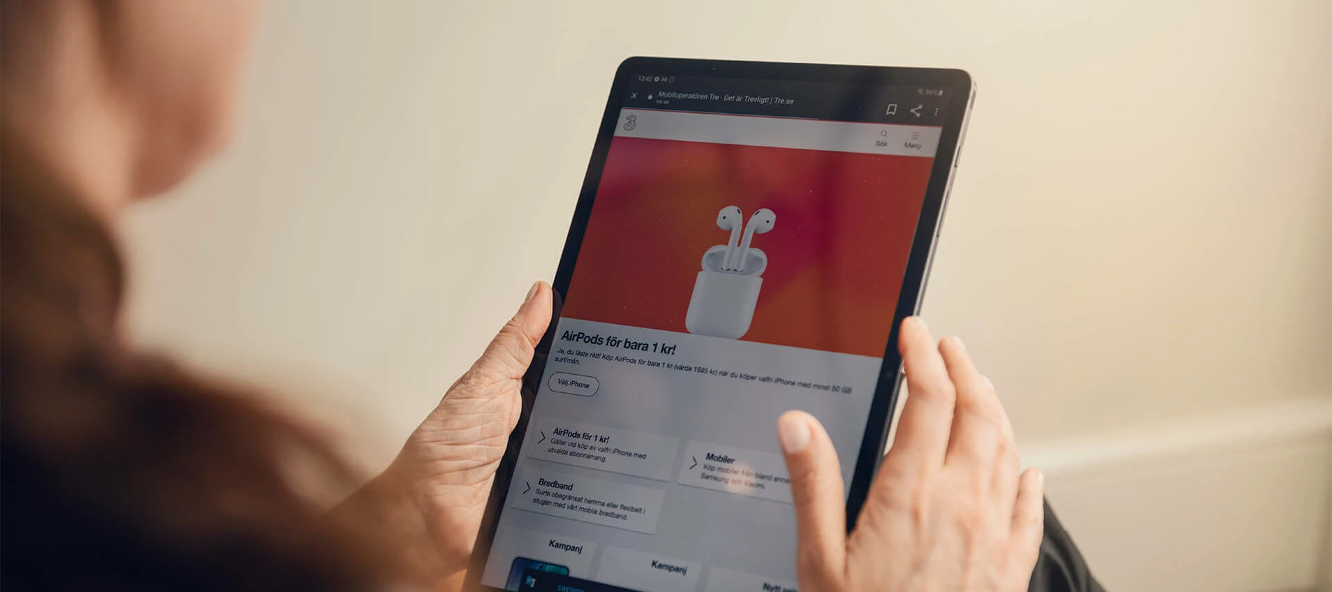Kvinna som surfar på tre.se med surfplatta.