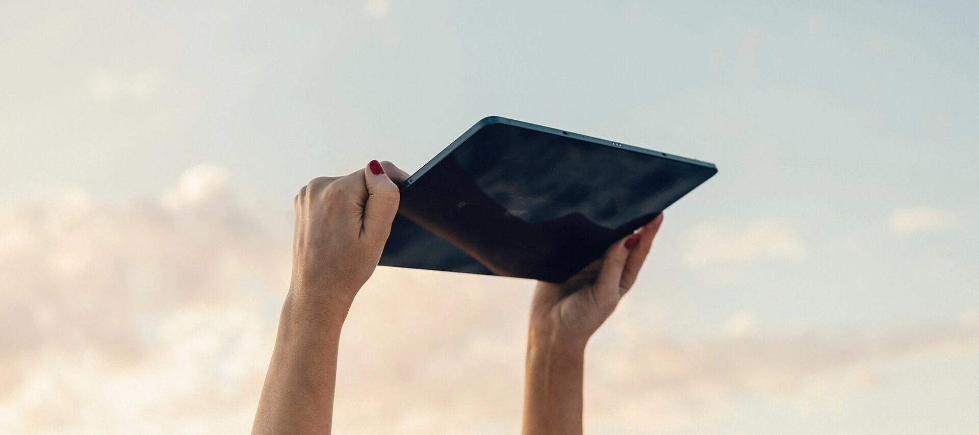 Surfplatta som riktas uppåt mot kvällshimmel.